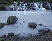 Larga exposición de la cascada de Hraunfossar en Islandia - foto de stock