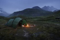 Scenic view of green tent by Jotunheimen range at dusk — Stock Photo