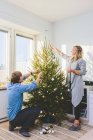 Vista lateral do casal decoração árvore de Natal juntos — Fotografia de Stock