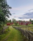 Сільська сцена з дерев'яним парканом і фулу червоними будинками — стокове фото