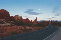 Road stretching beside rock formations in Arches National Park — Stock Photo