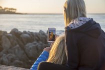 Girl taking pictures selfie with mother in Pacific Grove — Stock Photo