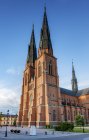 Sol iluminado catedral de Uppsala bajo el cielo azul - foto de stock
