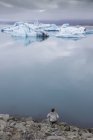 Турист на берегу озера Йокульсарлон в Исландии — стоковое фото