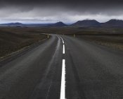 Road and mountain range under cloudy sky — Stock Photo