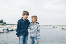 Boys standing next to marina and laughing, focus on foreground — Stock Photo