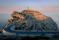 Lighthouse on edge of cliff in evening sunlight, Cap Formentor, Spain — Stock Photo