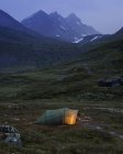 Illuminated tent by Jotunheimen range at dusk — Stock Photo