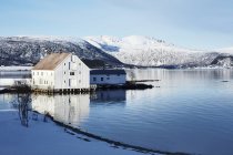 Casa blanca junto al lago en invierno, Noruega - foto de stock