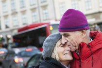 Senior couple hugging in street, focus on foreground — Stock Photo