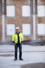 Portrait of man in reflective clothing with building in background — Stock Photo