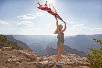 Jeune femme tenant le drapeau américain au Grand Canyon — Photo de stock