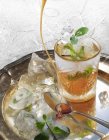 Cocktail fresco de hortelã gelada com mel derramando na bandeja de prata — Fotografia de Stock