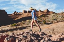 Vue latérale de la femme marchant sur les rochers dans le parc national des Arches — Photo de stock
