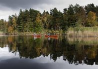 Man paddling canoe on lake — Stock Photo