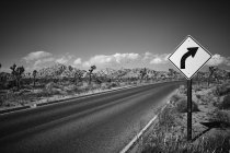 Road sign by empty road in Joshua Tree National Park — Stock Photo