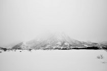 Vista de la montaña nevada cubierta de niebla - foto de stock