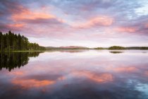 Vista panoramica del cielo al tramonto che si riflette nell'acqua del lago — Foto stock