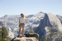 Дівчина дивиться на вид з дозорного купола і Yosemite Falls — стокове фото