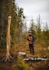 Жіночий мисливець використання супутникового телефону в лісі — стокове фото