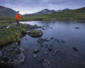 Man fishing in lake Sjuendevatnet at dawn — Stock Photo