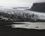 Ghiacciaio e rocce nella nebbia, bianco e nero — Foto stock