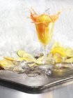 Orange slice splashing in cocktail on silver tray — Stock Photo