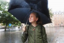 Балансова парасольку дівчина і посміхаючись, зосередитися на передньому плані — стокове фото
