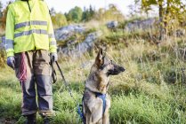 Voluntário com cão ajudando serviços de emergência encontrar pessoas desaparecidas — Fotografia de Stock