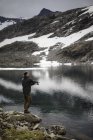 Vista lateral do homem que pesca perto da escala de Jotunheimen — Fotografia de Stock