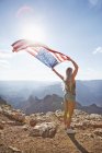 Mujer joven con bandera estadounidense en el Gran Cañón - foto de stock