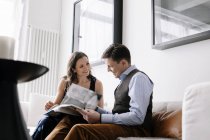 Couple sitting on sofa and reading book, selective focus — Stock Photo