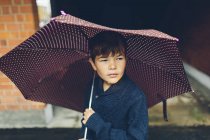 Ritratto di ragazzo con ombrello in mano, fuoco selettivo — Foto stock