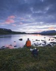 Людина, що риболовля на озері Sjuendevatnet на заході сонця — стокове фото