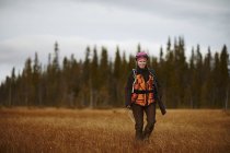 Жіночий мисливець ходити в поле, зосередити увагу на передньому плані — стокове фото