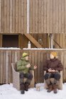 Люди відпочивають перед дерев'яним будинком — стокове фото