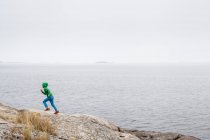 Boy running by lake, selective focus — Stock Photo