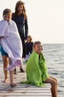 Children and mother on jetty, focus on foreground — Stock Photo