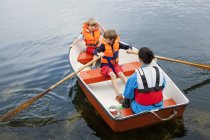 Mulher com dois meninos no barco a remos, foco seletivo — Fotografia de Stock
