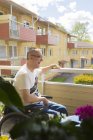 Человек на инвалидной коляске на балконе, дифференциальная фокусировка — стоковое фото