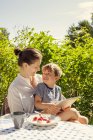 Portrait of son and mother using digital tablet in garden — Stock Photo