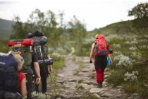 Rear view of people hiking with backpacks, selective focus — Stock Photo