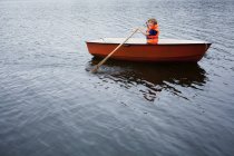 Boy in red rowboat, selective focus — Stock Photo