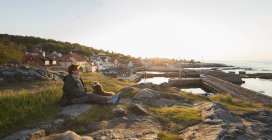 Літня жінка з собакою, сидячи на берегової лінії на Борнхольм, Данія — стокове фото