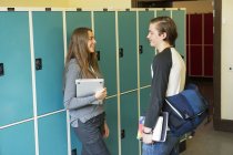 Vista laterale degli studenti che parlano nel corridoio scolastico — Foto stock