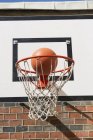 Aro de basquete com bola em luz solar brilhante — Fotografia de Stock