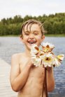 Portrait of boy holding flowers, focus on foreground — Stock Photo