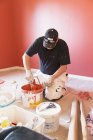 Mature manual worker painting wall, selective focus — Stock Photo