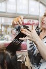 Hairdresser cutting customers hair, selective focus — Stock Photo