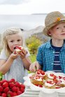 Children eating strawberry dessert, outdoors — Stock Photo